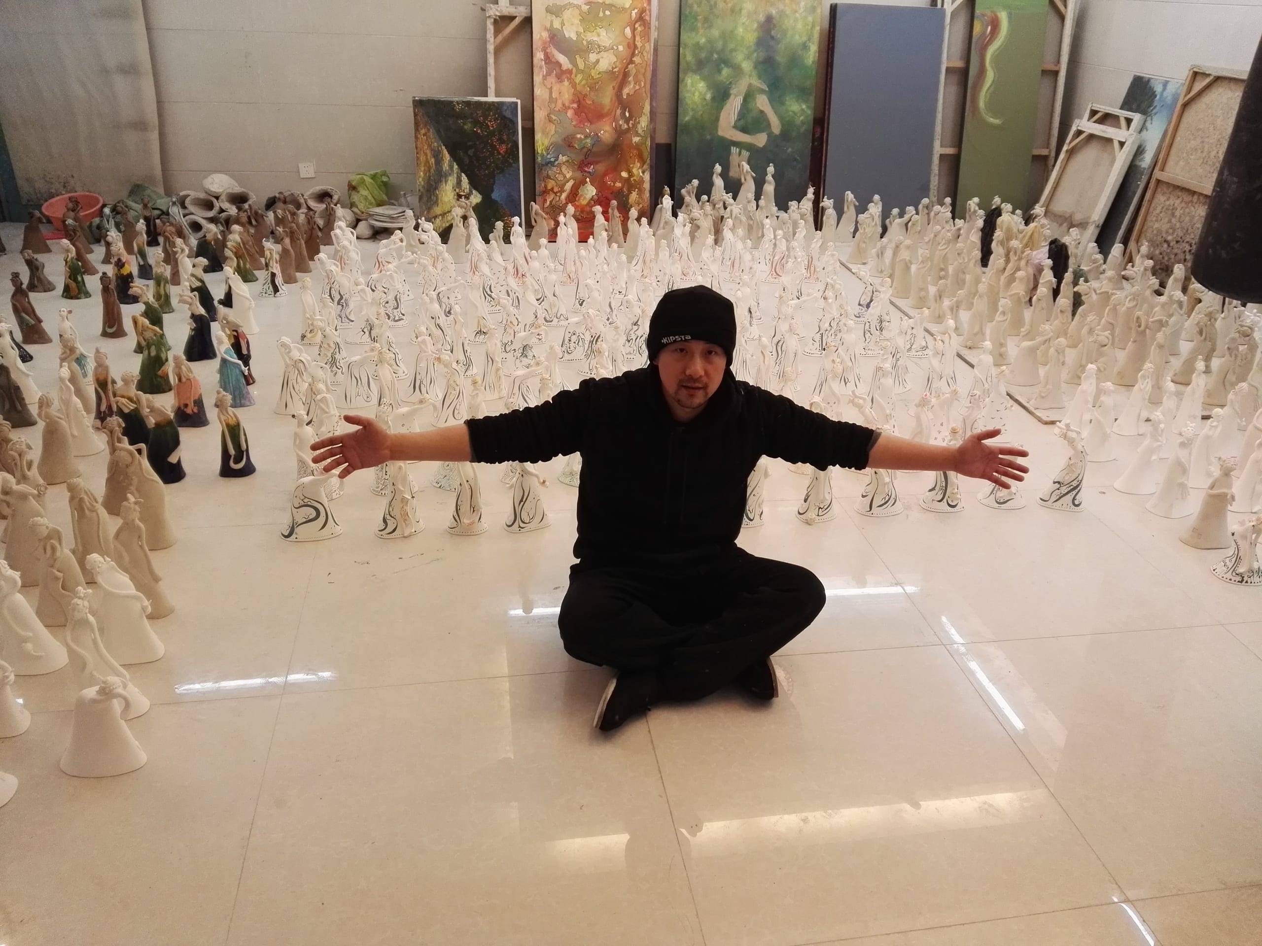 Lu Renjie in the studio among hundreds of unglazed ceramic figures